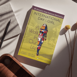 A copy of the book on a table with minimal neutral decorations. There are some shadows indicating a nearby window, with sunlight shining on the book in the center of the image.